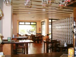 a restaurant with wooden tables and chairs and a dining room at Hotel O Lagar in Cambados