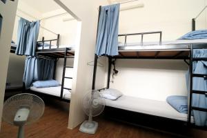 Una habitación con dos literas y un ventilador. en Krit Hostel, en Bangkok