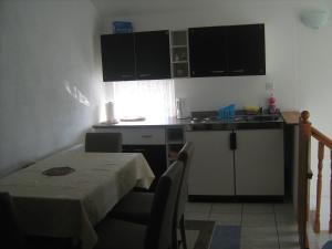 a small kitchen with a table and a table and chairs at Apartment Jopa in Korenica +47 photos