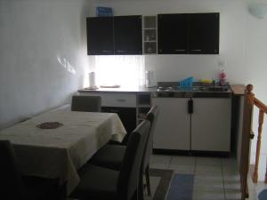 a small kitchen with a table and a table and chairs at Apartment Jopa in Korenica