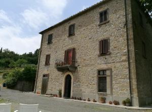 a large stone building with a balcony on it at I Castagnini in Montecatini Val di Cecina