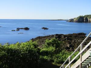 a view of the ocean with rocks in the water at The 8th Maine Regiment Lodge and Museum in Peaks Island