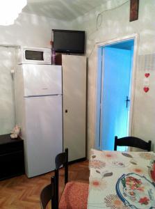 a kitchen with a refrigerator and a table and a table and a room at Apartment Filip in Vrbnik