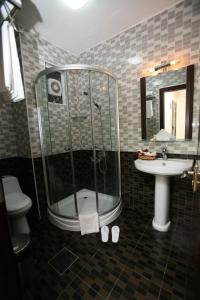 a bathroom with a shower, sink, and toilet at Cedar Hotel in Aqaba