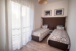 シラクーサにあるDomus Claudia - Casa Vacanzeのベッドルーム1室(ベッド2台、窓付)