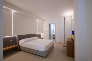 een witte slaapkamer met een bed en een kast bij Seven Suite in Gallipoli