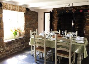 a dining room with a green table and chairs at Blisland Cottage in Blisland