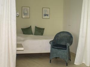 ein Schlafzimmer mit einem Bett und einem Stuhl darin in der Unterkunft Ferienwohnung im Wikingturm mit Blick auf die Schlei - Willkommen in Schleswig! in Schleswig
