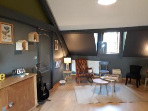 uma sala de estar com guitarras, uma mesa e cadeiras em L'escale du XIX ème em Lillers