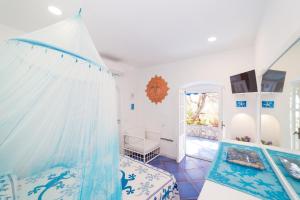 涅納羅的住宿－Blue eyes，一间卧室配有一张带蚊帐的床