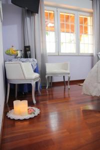 a living room with a table and two chairs and candles at Il Giardino delle Jacaranda in Talsano