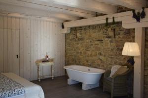 ein Schlafzimmer mit einer Badewanne in einem Zimmer mit einem Bett in der Unterkunft Sárffy House in Dörgicse