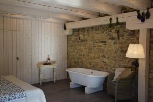 a bedroom with a bath tub in a room with a bed at Sárffy House in Dörgicse