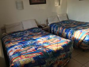 dos camas sentadas una al lado de la otra en una habitación en Relax Inn Forth Worth, en Fort Worth
