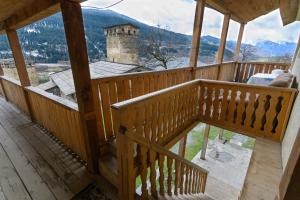 a wooden balcony with a view of a castle at Guest House Keti Margiani Mestia in Mestia