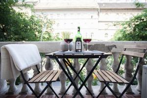 a table with a bottle of wine and two glasses at Oktogon Luxury Apartment in Budapest