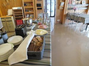 a long table with plates and a basket of food at Bed & Breakfast Pohjan Tuli in Utsjoki