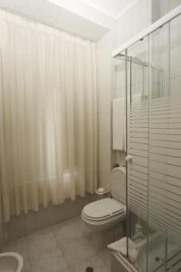 a bathroom with a toilet and a glass shower at Hotel Leiriense in Leiria
