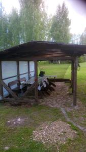 a wooden pavilion with a picnic table in a field at Dižāpas in Usma