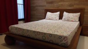 una camera da letto con letto e lenzuola e cuscini rosa e verdi di Residence Cheikh Fall a Dakar