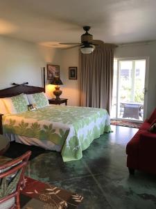 um quarto com uma cama e uma ventoinha de tecto em Hale Pua Villa - Seaside Studio em Koloa