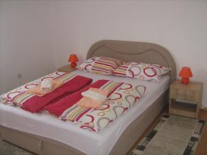 a bed with two blankets and two pillows on it at Apartment Jopa in Korenica
