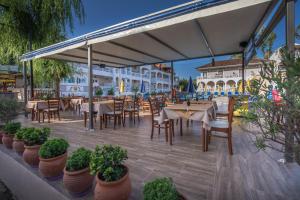 un patio al aire libre con mesas, sillas y plantas en Ragias Studios, en Tsilivi