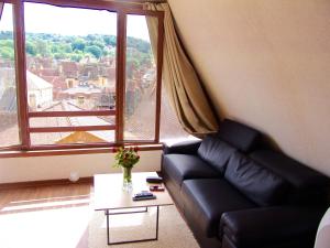 a living room with a couch and a large window at FRANRÉAL, 4 Appartements in Sarlat-la-Canéda