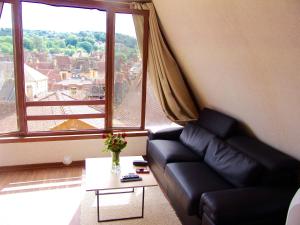 a living room with a couch and a large window at FRANRÉAL, 4 Appartements Climatisés in Sarlat-la-Canéda