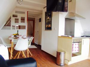 uma pequena cozinha com uma pequena mesa e uma cozinha com um balcão em FRANRÉAL, 4 Appartements em Sarlat-la-Canéda