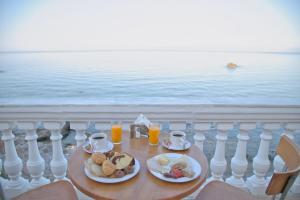 un tavolo con due piatti di cibo e succo d'arancia di Elea Mare a Elia Laconias
