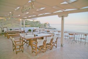 ein Restaurant mit Tischen und Stühlen und Meerblick in der Unterkunft Elea Mare in Elia Laconias