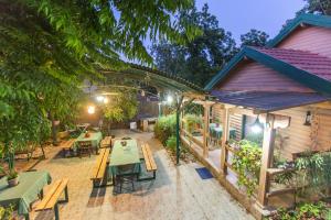 an outdoor patio with tables and benches and a restaurant at Leyad Hashmura Lodging in Yesod Hamaala
