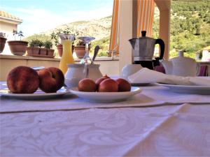 a table with plates of fruit on a table at Bed and Breakfast BLUE in BLUE in Komiža