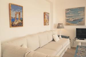 a living room with a white couch and a tv at Villa Mozaik in Plaka