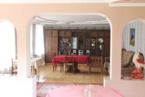 a living room with a table and a red table cloth at Iason Guest House in Mazeri in Mestia