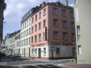 een roze gebouw aan de kant van een straat bij Hotel Angleterre in Cherbourg en Cotentin