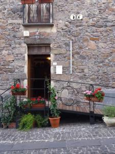 een stenen gebouw met bloempotten en een balkon bij Casa Castori in Macomer