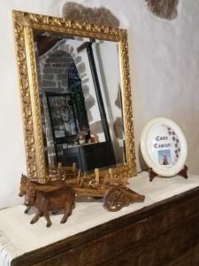 un espejo en la parte superior de un tocador con reloj en Casa Castori, en Macomer