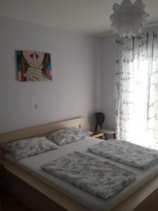a bedroom with a bed and a painting on the wall at Apartments Katica in Rab