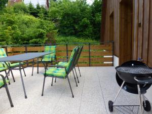 a patio with a table and chairs and a grill at Horský apartmán Draps in Ostružná
