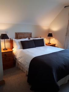 a bedroom with a large white bed with two lamps at The Creggs in Ballyvaughan