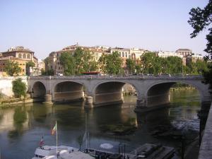 a bridge over a river with boats and buildings at FAIROME Apartment Cassia in Rome