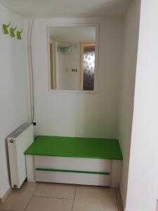 - un banc vert dans une pièce avec un miroir dans l'établissement Apartman Anni, à Poreč