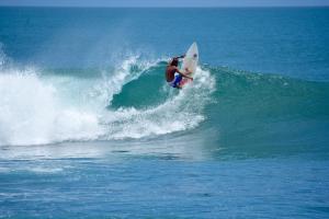 a man riding a wave on a surfboard in the ocean at Wild Waves Surf-House in Popoyo