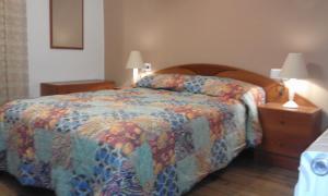 リベス・デ・フレセルにあるAllotjament Tagaのベッドルーム1室(ベッド1台付)、2泊分のスタンド(ランプ付)