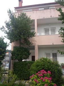 a building with pink flowers in front of it at Apartments Katica in Rab