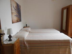 Casa sul bosco في Roa Marenca: غرفة نوم بها سرير وطاولة ومصباح