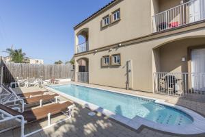 einen Pool mit Stühlen und ein Haus in der Unterkunft Campeche in South Padre Island