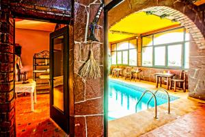 a room with a swimming pool in a building at Jad Auberge in Ourika